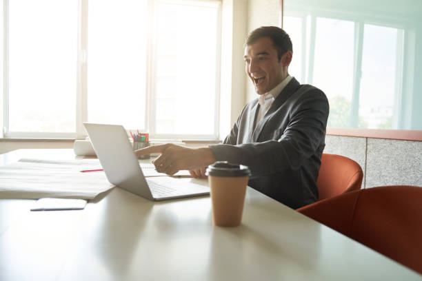istock Excited man pointing at laptop display at office desk 1402914506