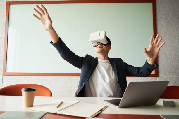 istock Male white collar worker enjoying VR environment through goggles 1402915020
