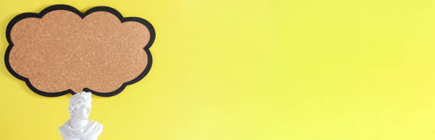 istock gypsum statue with blank sign on yellow background. copy space, advertisement, presentation. New ideas, creativity and think out of the box banner 1402915166