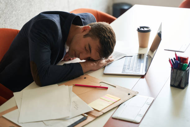 istock Exhausted office worker sleeping on desk near laptop 1402915167