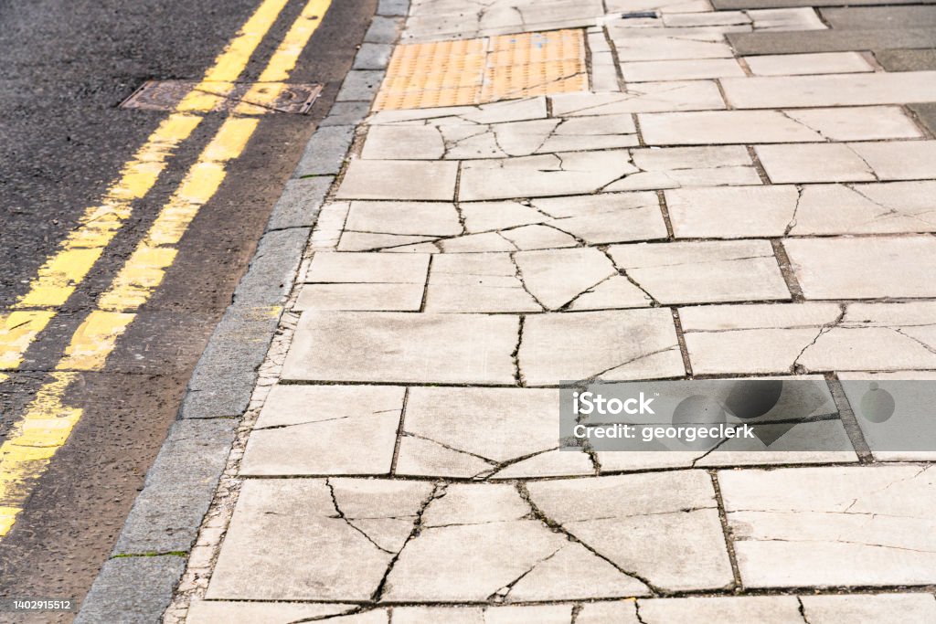 Heavily damaged pavement Paving stones on a British street badly damaged by vehicles using the pavement. Antique Stock Photo