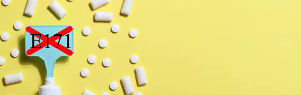 istock Titanium dioxide, E171, dangerous additive concept. gum, pills, toothpaste or cream and sign with E171 on yellow background. copy space banner 1402916403