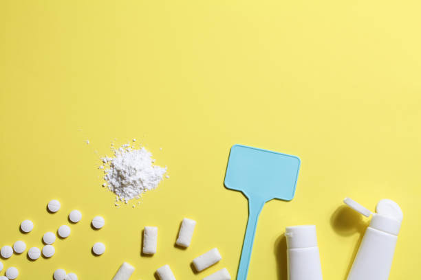 istock Titanium dioxide, E171, dangerous additive concept. gum, pills, toothpaste, powder and sign with space on yellow background. copy space 1402916431