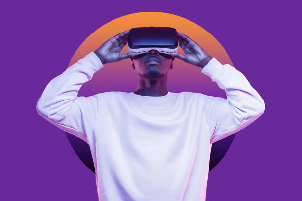 African american man looking up at virtual reality or metaverse in vr glasses isolated on purple African american man looking up in vr glasses, playing video games, experiencing interactive metaverse, dressed in white mockup sweatshirt with blank copy space, isolated on violet wall with circle virtual reality point of view stock pictures, royalty-free photos & images