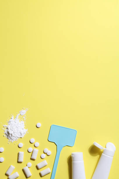 istock Titanium dioxide, E171, dangerous additive concept. gum, pills, toothpaste, powder and sign with space on yellow background. copy space 1402916466