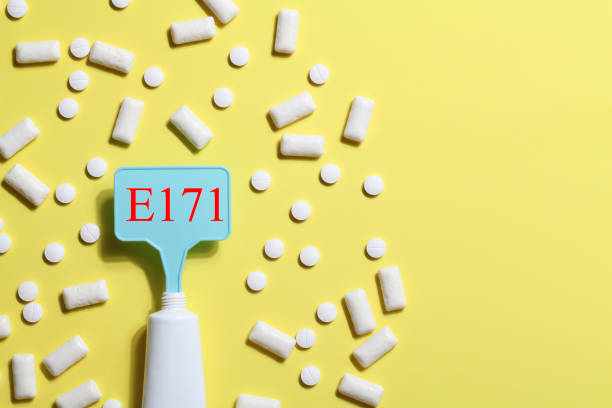 istock Titanium dioxide, E171, dangerous additive concept. gum, pills, toothpaste or cream and sign with E171 on yellow background. copy space 1402916478