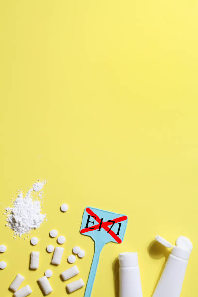 Titanium dioxide, E171, dangerous additive concept. gum, pills, toothpaste, powder and sign with E171 on yellow background. copy space