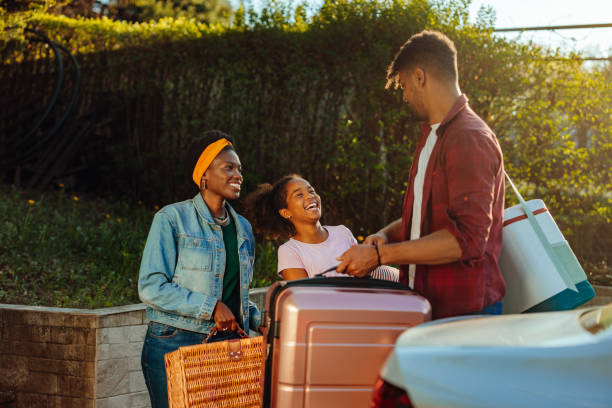 Family unloading luggage from the car for summer vacation