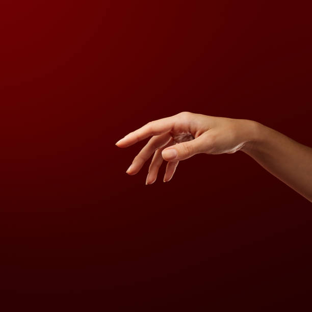 Elegant female hand facing down against red background