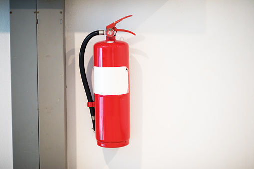 Red fire extinguisher at wall inside of condominium