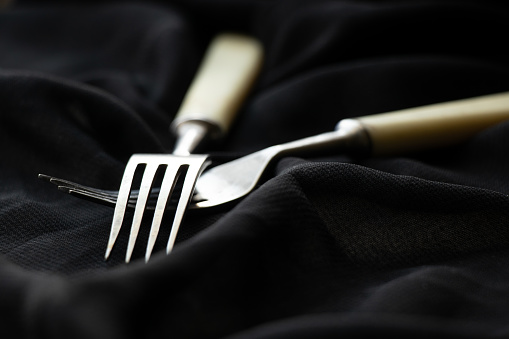 Old forks on a black background close-up, kitchen utensils, cutlery vintage