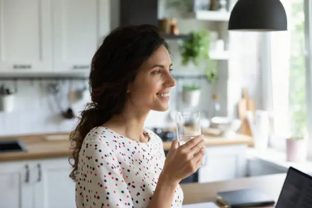 Photo of Happy female freelance employee working at laptop from home