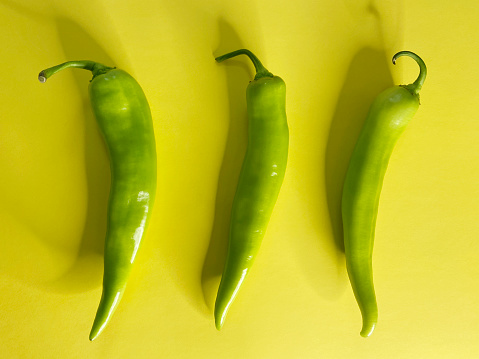 Group of green peppers on the yellow background