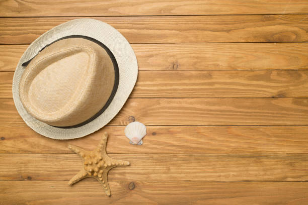 istock Wicker hat and seashells on wooden background, top view 1402937741