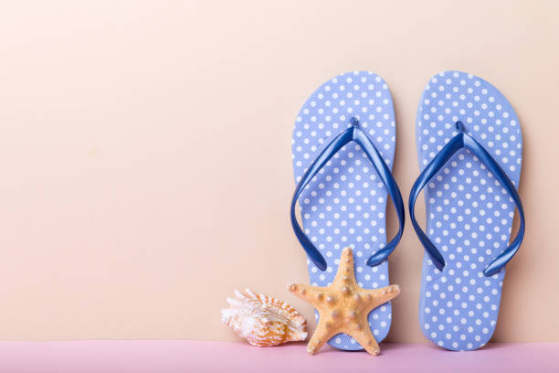 istock Beach accessories. Flip flops and starfish on colored background. Mock up with copy space 1402941094