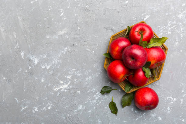 istock Many red apples on colored background, top view. Autumn pattern with fresh apple above view with copy space for design or text 1402942370