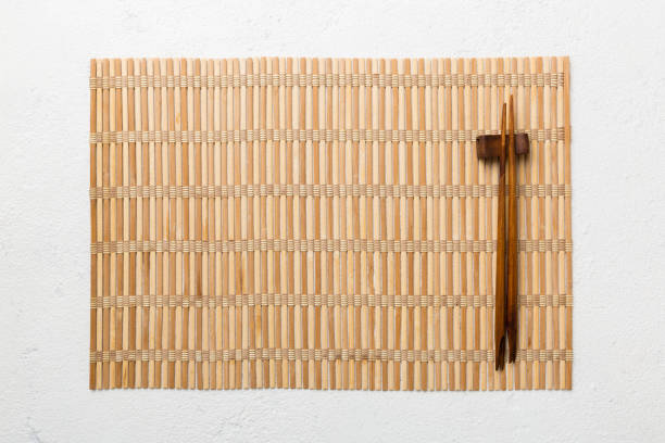 istock Two chopsticks and bamboo mat on cement background. Top view, copy space 1402942406
