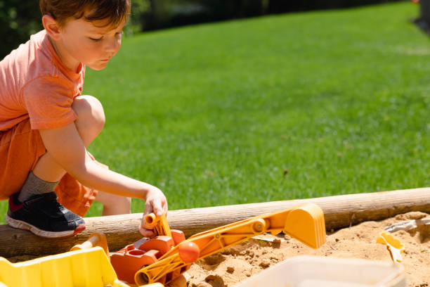 istock Young boy playing with sand toys in sandbox 1402943419