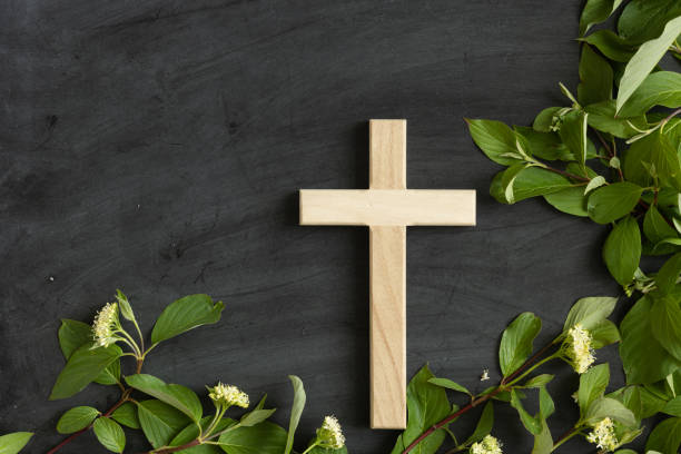 istock Cross on chalkboard background with green leaf border 1402943445