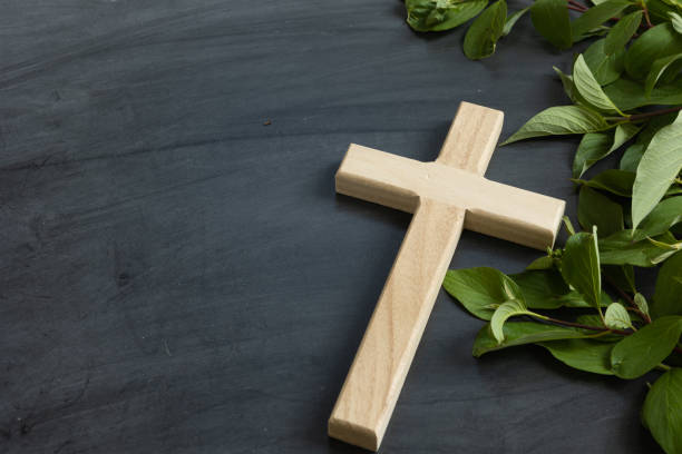 istock Wood cross on chalkboard background with green leaf border 1402943455