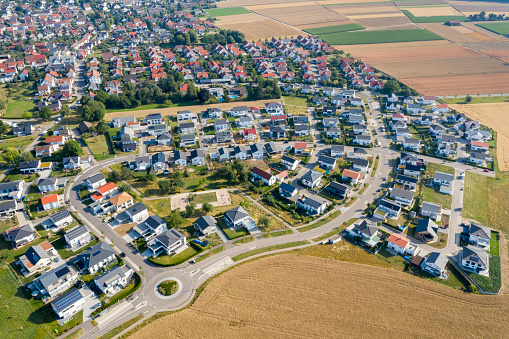 Aerial perspective of housing estate between green fields in spring landscape.