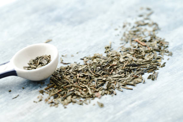 istock Dried Green Tea Leaves on rustic stone Background. Top view. Copy space. 1402946916