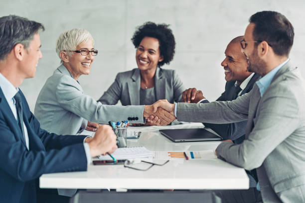 businesswoman and businessman shaking hands across the table - teamwork conference team business meeting imagens e fotografias de stock