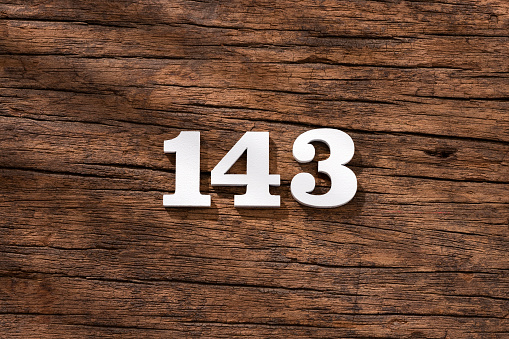 Number 143 - piece on rustic wood background
