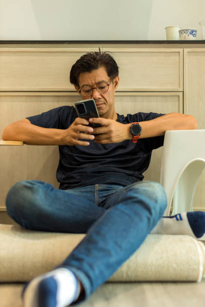 istock Man sit down and using mobile and social media. Man playing on him Smart phone 1402954206