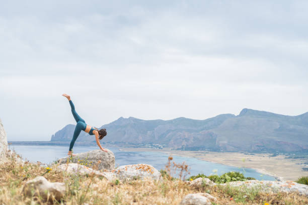 istock Young woman practices yoga at coastal viewpoint 1402962379