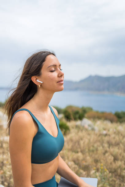 istock Young woman relaxes at coastal viewpoint 1402962459
