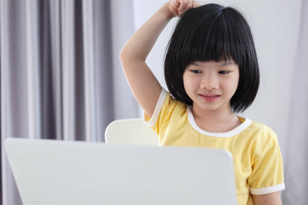 istock little asian girl student study online using laptop computer at home 1402962632