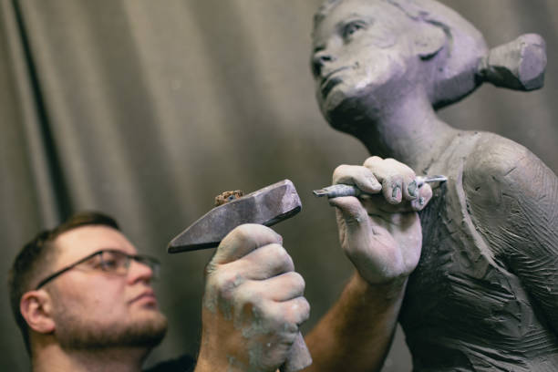 istock Man sculptor creates sculpt bust human woman sculpture. Statue craft creation workshop 1402962640