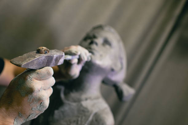 istock Man sculptor creates sculpt bust human woman sculpture. Statue craft creation workshop 1402962641