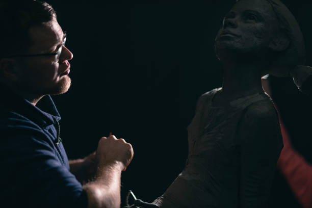 istock Man sculptor creates sculpt bust clay human woman sculpture. Statue craft creation workshop 1402962643