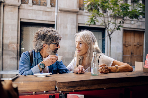Portrait of a mature couple on vacation enjoying coffee at the open air cafe in Barcelona.