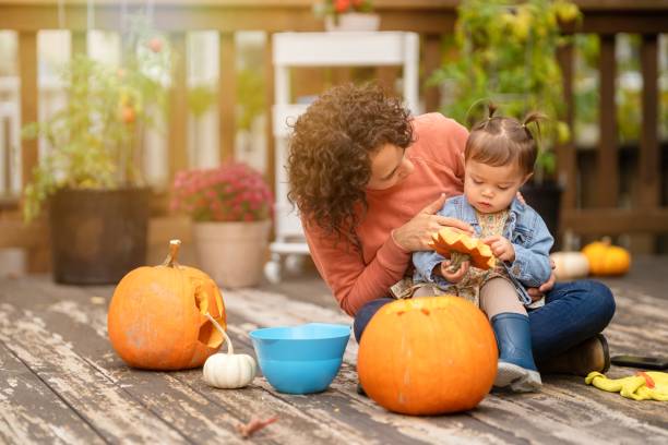 mamá e hija tallando calabazas en el patio trasero - halloween pumpkin party carving fotografías e imágenes de stock