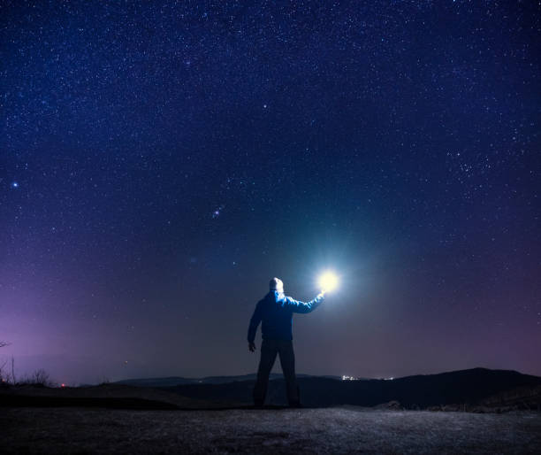 istock Man with light at night in nature. 1402962959