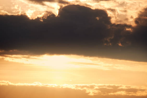 istock Dark clouds in the evening sunset sky with the setting sun. Dramatic sky during orange sunset 1402963023