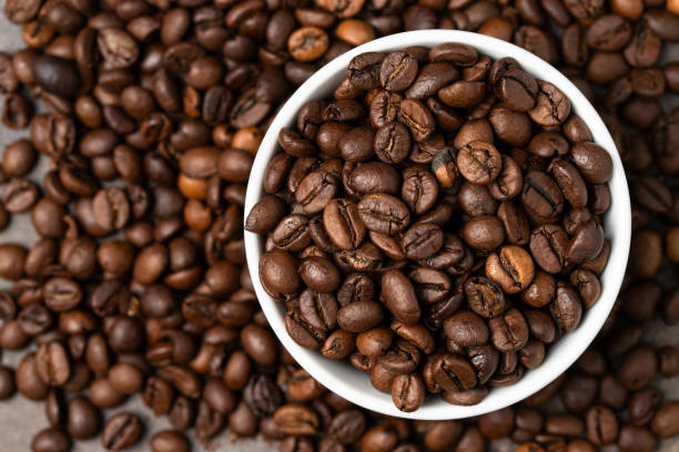 istock Close up of coffee beans texture.White bowl with coffee beans . 1402963143