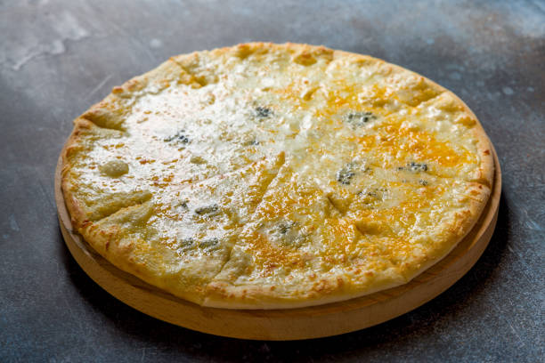 istock Pizza Quattro formaggi on the board on dark blue stone table 1402967477