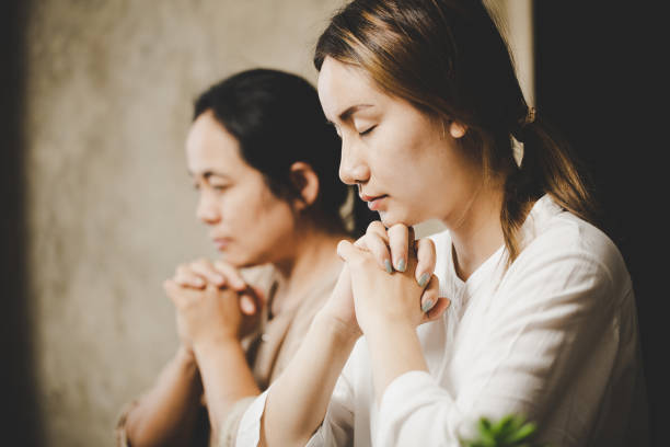 istock Two women praying worship believe 1402981457