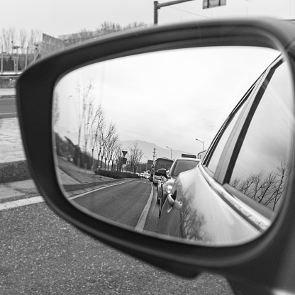 Sunset in the mirror, on the road, the mirror on the left side of the car