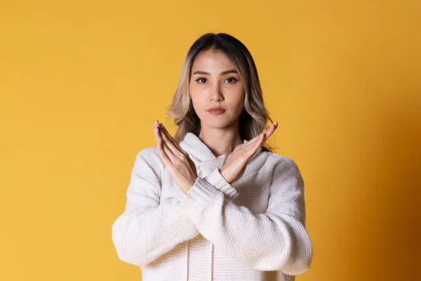 portrait of beautiful young asian woman wearing yellow jacket posing with hands isolated over gray background.Break The Bias of International women's day.