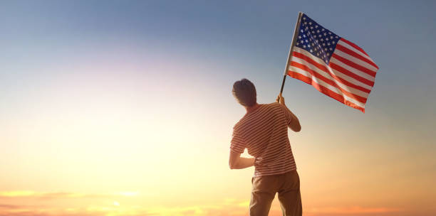 istock Patriotic holiday, man with American flag 1402987262