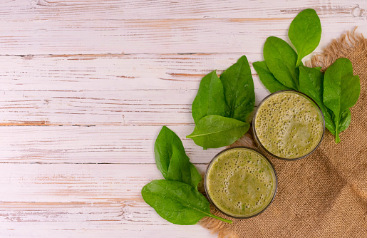 Healthy spinach smoothie on a white wooden background.Copy space.