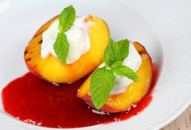 istock Grilled peaches with mascarpone and strawberry jam on white plate 1402987571