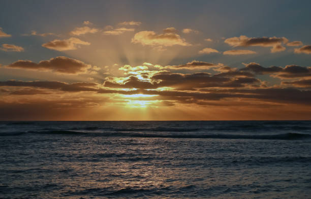 istock Seascape, sunset over the sea, the sun s rays break through the clouds, dramatic sky 1402990812
