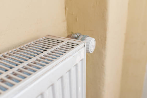 istock Old white heating radiator thermostat.closeup,selective focus,yellow background. 1402992485