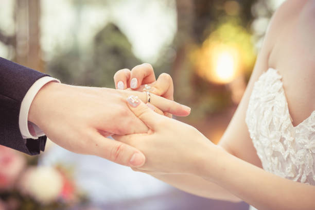 istock Bride Put on Wedding Ring Groom Hand 1402994878